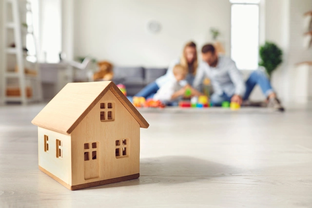Photo d'une famille en arrière plan avec une maison en bois au premier plan